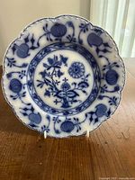 Front view of flow blue Johnson Brothers Holland plate on stand