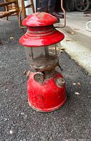 Full view of red metal propane lantern on driveway