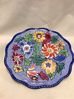 Front view of plate showing floral design and scalloped edge