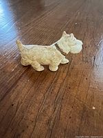 Left side view of cream plastic Scottie dog figurine with brown collar