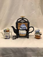 Front view of teapot with creamer and sugar bowl
