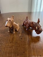 Both wooden dog figurines on table