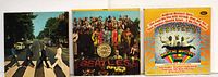 Front view of three Beatles LP jackets: Abbey Road, Sgt. Pepper, Magical Mystery Tour