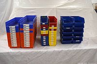 Three stacks of assorted size plastic storage bins