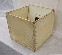 Angled front view of off-white wooden finger-jointed box holding vinyl records