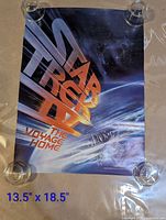 Front view of full poster held by weights showing entire artwork and dimensions overlay