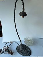 Full view of metal desk lamp with curved stem, ornate base, power cord and socket visible
