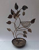 Full view of bronze-tone metal tree jewelry stand with bird, nest, leaf earring holders and base tray