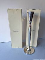 Two Calvin Klein Home boxes and one candlestick on display