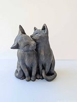 Three-quarter front view of twin-cat bronze sculpture