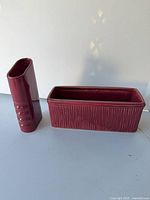Tall narrow burgundy vase and rectangular planter side by side
