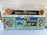 Front of sealed Hollywood Edition Monopoly board showing logo, GO space and dice under shrink wrap