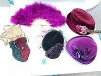 Group view of three hats, feather fan and two suede pouches
