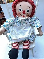 Frontal view Raggedy Ann seated on white toddler chair