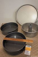 Perforated pizza platter, two springform pans, angel food cake pan