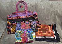 Weekend bag, cat motif silk scarf, geometric silk scarf displayed together