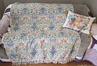 Throw draped over sofa with coordinating pillow visible
