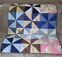 Front view of patchwork lap quilt showing pinwheel design