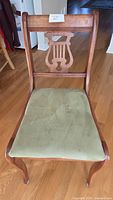 Front view of wood lyre-back chair with green suede-like seat