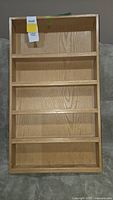 front view of oak spice rack showing four shelves and natural wood grain