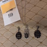 Necklace and earrings laid out showing pendant, stones and settings