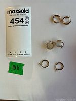 All three pairs of 10K gold hoop earrings with tag visible