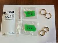 Full lot showing both earring pairs with 14K bags