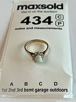 Full view of ring on auction card showing size reference