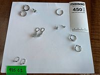 All five earring pairs and two singles laid out on white background with 925 CZ note visible