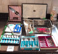 Overview of all boxed flatware sets, loose serving pieces, square basket