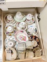 Drawer containing assorted teacups, saucers, cups, plates