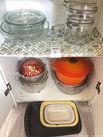 Overview of lot showing glass cookware on upper shelf and assorted bakeware on lower shelf