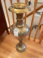 Full view of tall brass vase showing overall design and scale