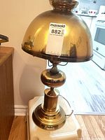 Full view of brass electric table lamp on stand