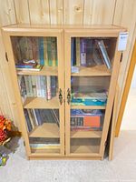 Front view of light wood glass-front bookcase with shelves