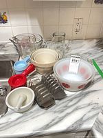 All items grouped on countertop: bowls, jugs, measuring cups, toast racks, mortar and pestle