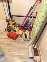 Overall lot with ironing board, stick vacuum, cleaning tools, toolbox and supply boxes