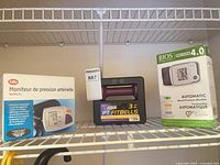Life blood pressure monitor box, PT Fitbells 3-lb weight, BIOS Precision 4.0 monitor box on shelf