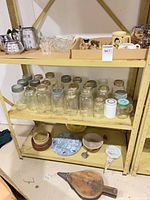 Overall view of shelves with percolators, glass items, jars, bowls, bellows