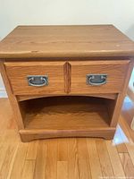 Front view of oak nightstand showing drawer and lower shelf
