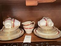 Stacked plates, cups, sugar bowl, creamer showing pattern