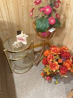 Side table, fern stand, artificial flowers grouped together