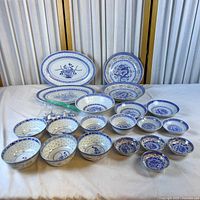 group shot of all 23 porcelain pieces showing range of sizes and patterns