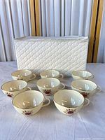 Group shot of eight Lenox Roselyn cups in front of white quilted case