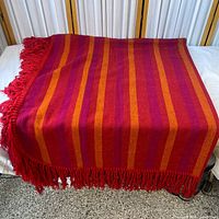 Full view of striped blanket on surface showing size and color