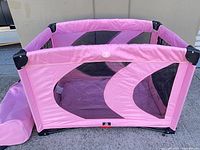 Overall view of pink folding pet playpen and separate carry bag