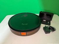 Top view of Kyvol robot vacuum, charging dock, power adapter
