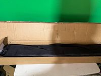 Cardboard shipping box containing carry bag with folded screen