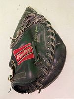 Front view of Rawlings catcher’s mitt showing red patch, lacing, nylon seam marking