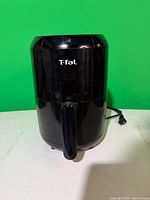 Front view of black T-fal air fryer with cord visible